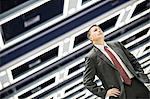 A view looking up at a Caucasian businessman walking through a convention centre arena.