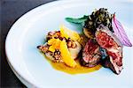 Beef tenderloin with chanterelle mushrooms, mandarin oranges, peanuts, collard greens, and grits