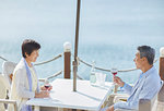 Japanese senior couple having a drink by the sea