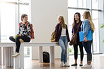 Female university students chatting together in university lobby