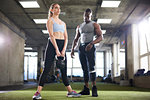 Trainer watching female client exercise with kettlebell in gym