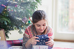 Curious girl holding Christmas gift