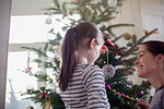 Mother and daughter decorating Christmas tree