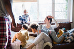 Multi-ethnic young family in pajamas playing in sunny living room