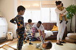 Multi-ethnic young family in pajamas playing and relaxing in living room