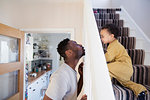 Playful father and toddler son crawling up stairs