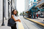 Businesswoman checking time by light rail line
