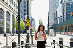 Businesswoman using cellphone by barriers