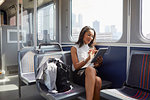 Businesswoman using digital tablet on train