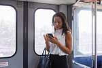 Businesswoman using cellphone in train