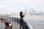 Businesswoman taking photograph of New York City skyline
