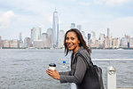 Businesswoman taking coffee break, New York City skyline in background