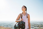 Woman carrying sports bag on hilltop, Los Angeles, US