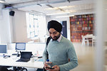 Indian businessman in turban using smart phone in office