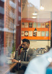 Businessman talking on smart phone, working in cafe