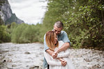 Affectionate couple hugging along stream