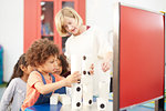 Teacher and curious students stacking large dominos in science center