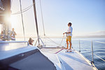 Young man holding rigging rope on sunny catamaran