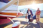 Men with bags boarding small airplane