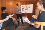 Creative designers brainstorming, reviewing proofs in office meeting