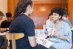 Smiling creative female designers discussing photograph proofs in office