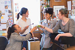 Creative female designers toasting green smoothies in office