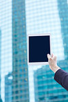 Hand holding tablet downtown Tokyo