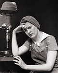 1940s WOMAN FACTORY WORKER SITTING BY DRILL PRESS MACHINE LOOKING EXHAUSTED TIRED ILL