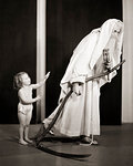 1930s NEW YEAR TODDLER BABY GIRL IN DIAPER BIDDING GOODBYE TO OLD FATHER TIME DRAGGING SCYTHE AND HUGGING EMPTYING HOUR GLASS