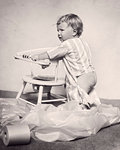 1920s AGGRAVATED DISTRAUGHT BABY STANDING BY POTTY CHAIR SURROUNDED BY UNROLLED PILE OF TOILET PAPER