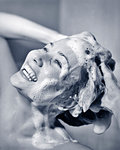 1950s HAPPY SMILING WOMAN SHAMPOOING HER HAIR LOTS OF LATHER