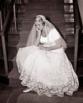 1950s JILTED SAD UNHAPPY BLOND BRIDE WEARING WEDDING DRESS SITTING ON CHURCH STAIRS