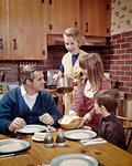 1960s 1970s MOTHER ABOUT TO SERVE FAMILY AT TABLE IN KITCHEN READY TO EAT