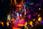 1960s 1970s ANONYMOUS CROWD OF TEENAGE AND ADULT PEOPLE DISCO DANCING UNDER COLORFUL PULSING STROBE LIGHTS