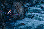 Man highlining above river, Truckee, California, USA