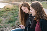 Girlfriends listening to music in park