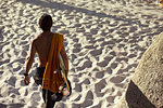 Mid adult male surfer carrying surfboard on beach, rear view, Camps Bay Beach, Cape Town, South Africa