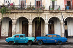 Two blue cars face nose to nose outside a dilapidated building, Havana, Cuba, West Indies, Caribbean, Central America