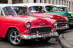 Red and green vintage American cars parked in a taxi rank near the train station, Havana, Cuba, West Indies, Caribbean