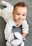 Baby boy lying on bed holding soft toy, portrait