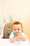 Smiling baby boy sitting in highchair