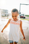 Smiling girl playing in public fountain in summer