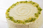 High angle view of a baked gin and tonic flavoured cake with icing and lime zest decoration