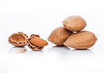 Raw almonds nuts with shell on white background with reflection