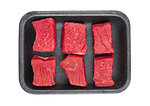 Pieces of fresh raw beef meat in plastic tray on white background