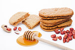 Healthy bio breakfast grain biscuits with honey and peanuts on white background