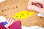 Travel holiday to United States of America concept with passport and flag with female hand scratching map choosing USA
