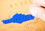 Travel holiday to Kazakhstan concept female hand coin choosing Kazakhstan