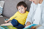 Japanese father and kid reading on the sofa