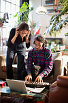 Young man and woman recording music, playing keyboard piano in apartment
